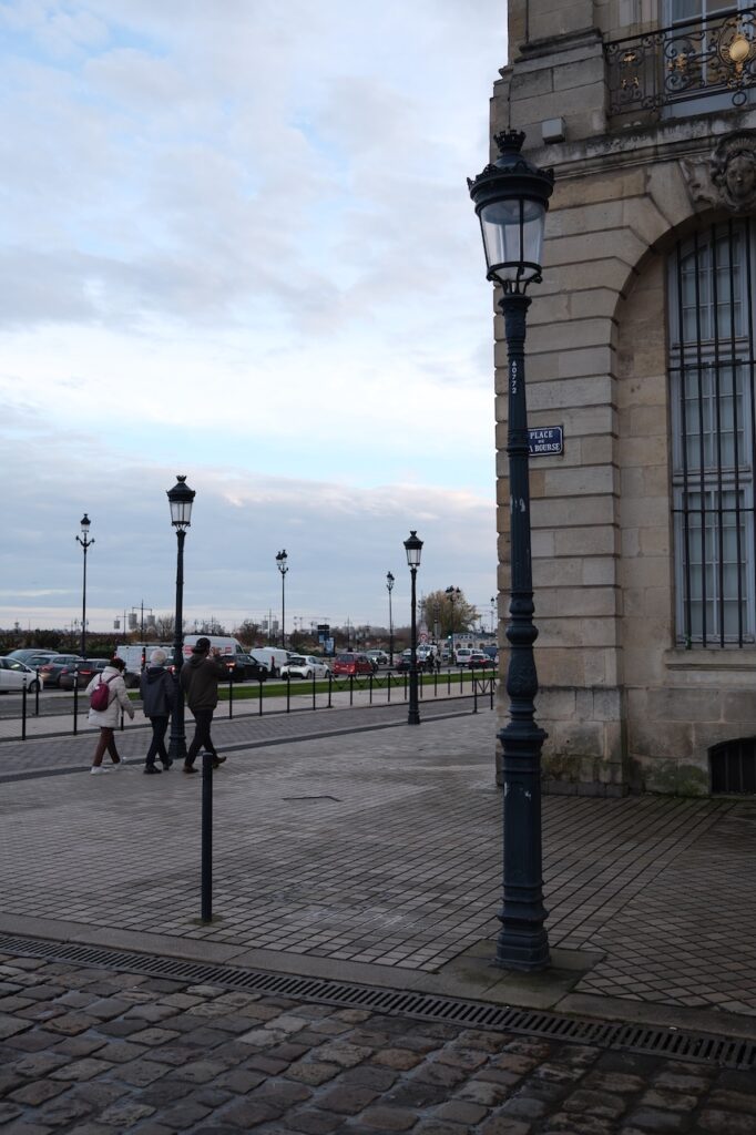 A town promenade lined with lampposts on an overcast day.
